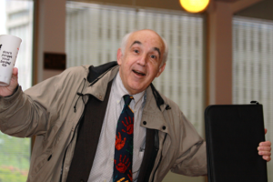 Joel Rosch holding coffee and a file folder