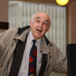 Joel Rosch holding coffee and a file folder